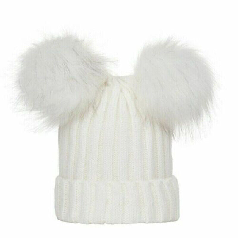 Soft white knitted hat with two pom poms on the top