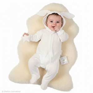 A white baby sleepsuit baby grow with white bunny ears on the hood