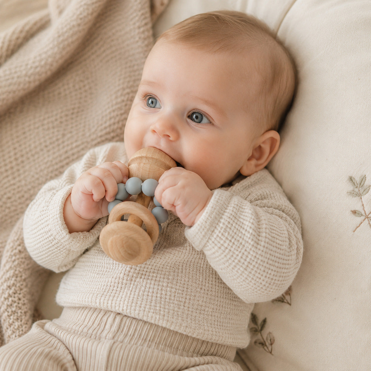 Wooden baby teething toy with pastel blue silicone beads
