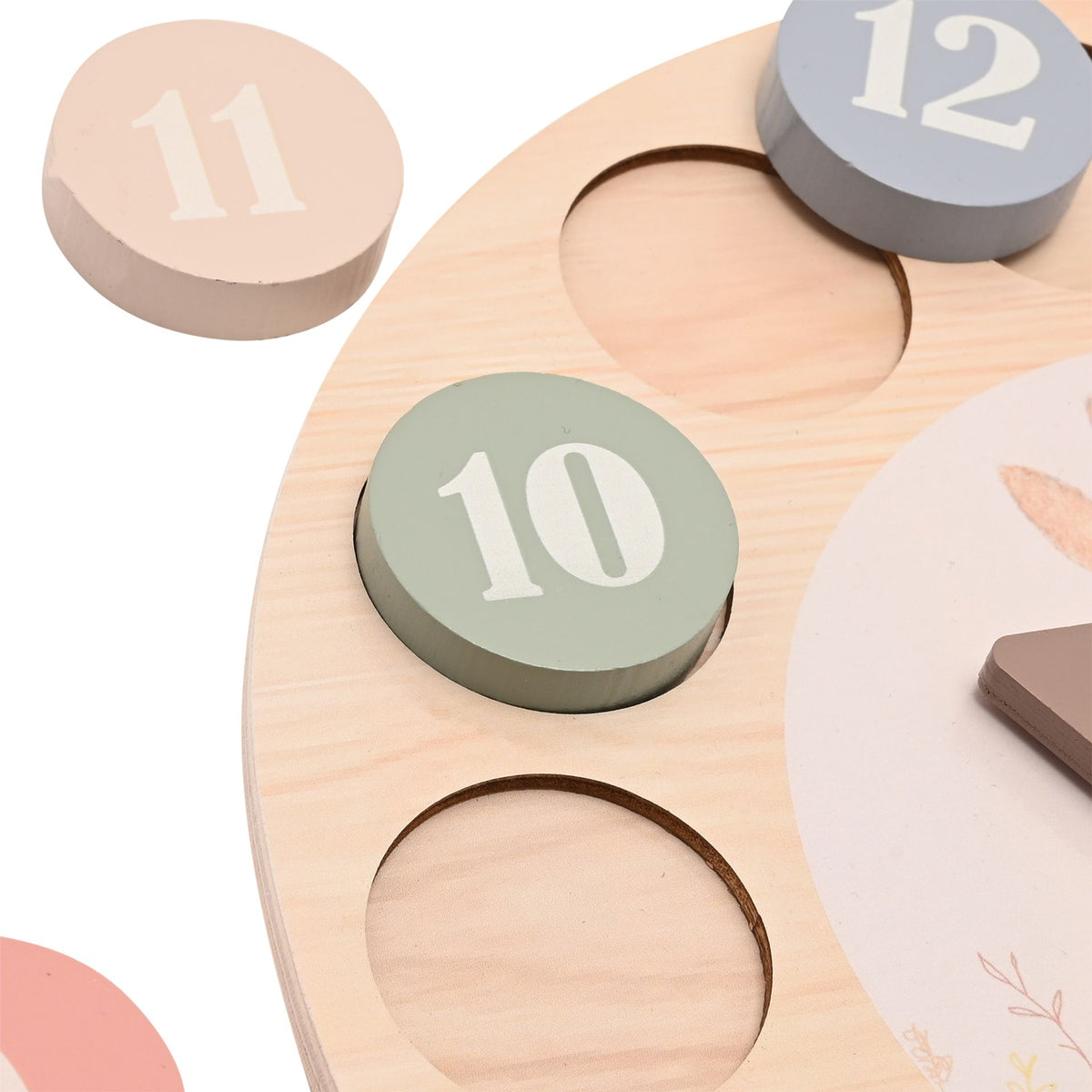 Close-up of number 10, 11 and 12 discs and recessed spaces on wooden learning clock