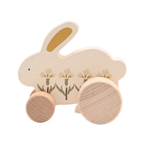 Side view of a cream wooden bunny with a small front wheel and larger rear wheel against white.
