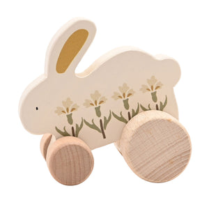 Close view of the wooden rabbit’s yellow inner ear, floral decoration and natural wood wheels.
