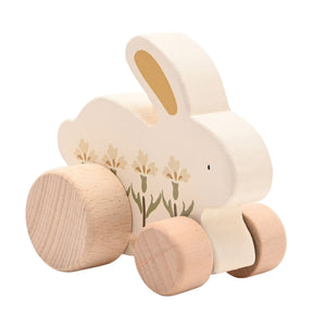 Reverse angled view of a floral wooden bunny showing its thick wooden body and wheels.