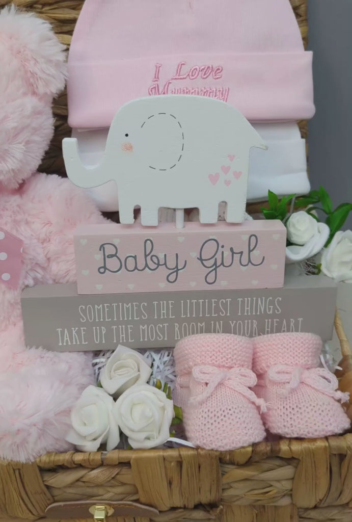 Baby girl gift hamper basket with teddy and other gifts.