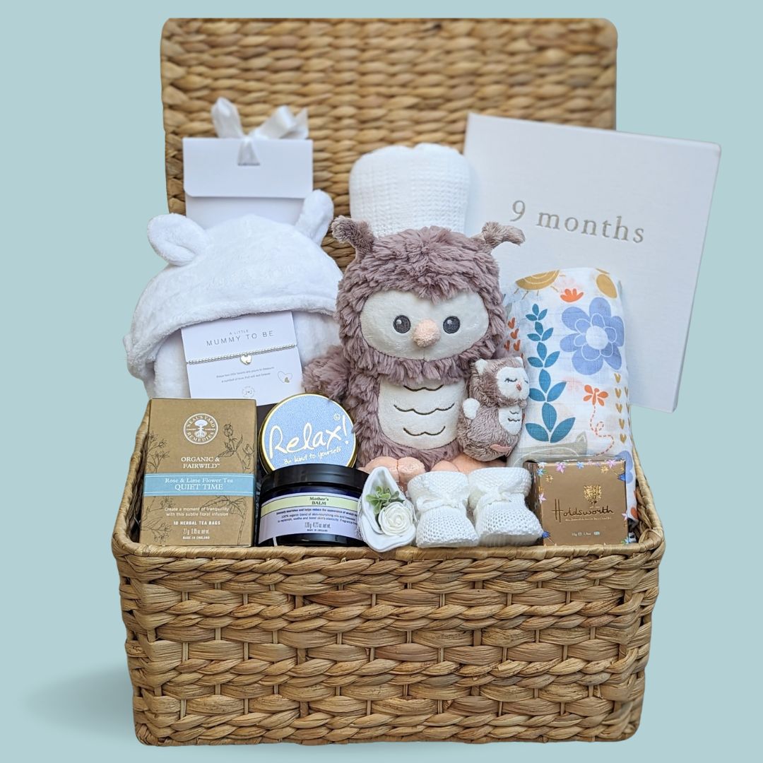 Baby shower hamper with stunning gifts for Mum and baby. Chocolates for the parents to be, organic tea, relaxation candle, silver bracelet and gifts for baby.