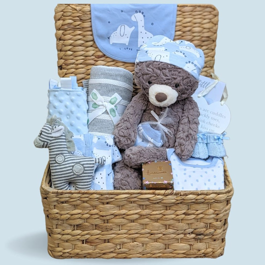 Baby boy hamper gifts with presents including blue baby clothes set, baby blanket, teddy bear, rattle and chocolates for mum.