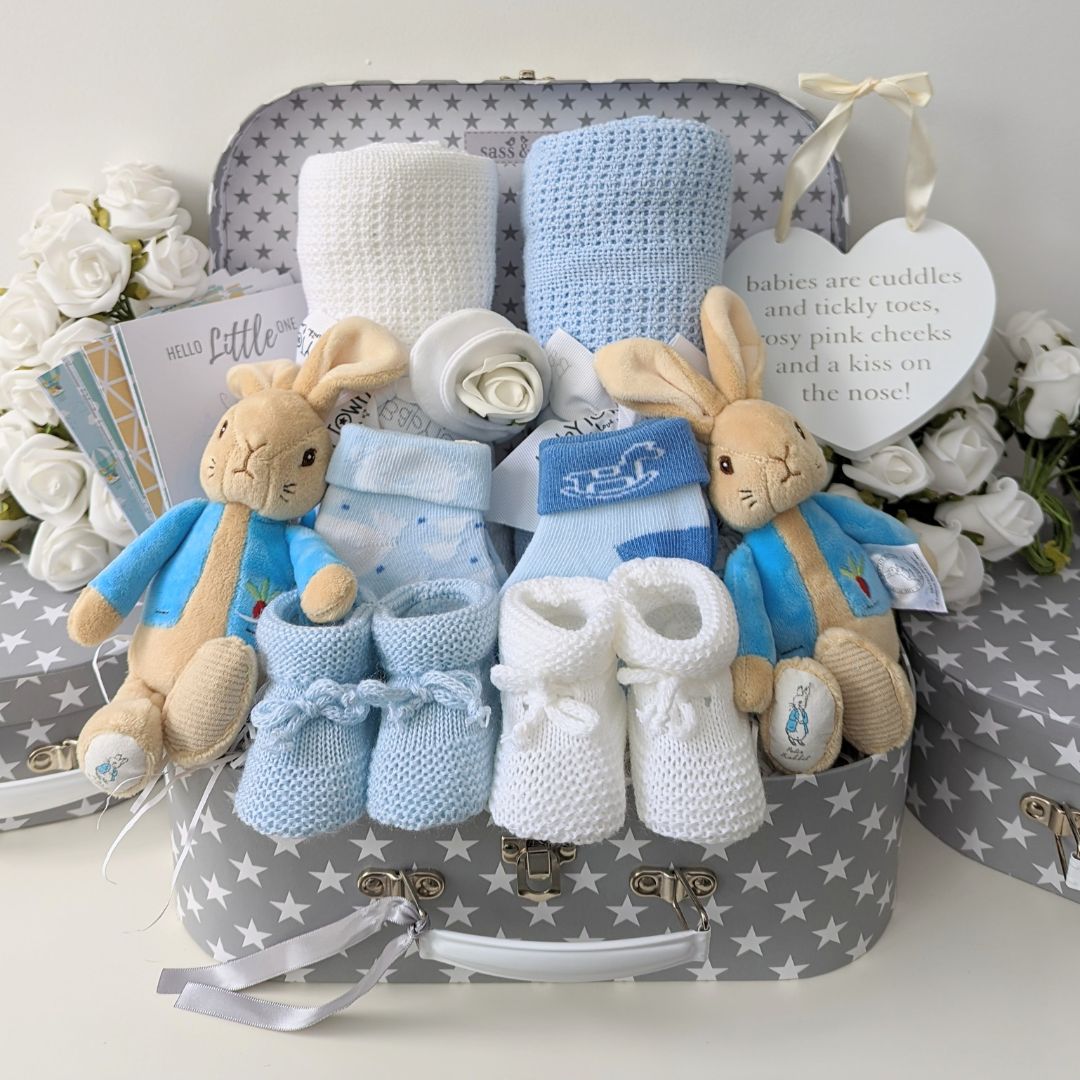 Twin baby gift hamper with peter rabbits and blue and white blankets.