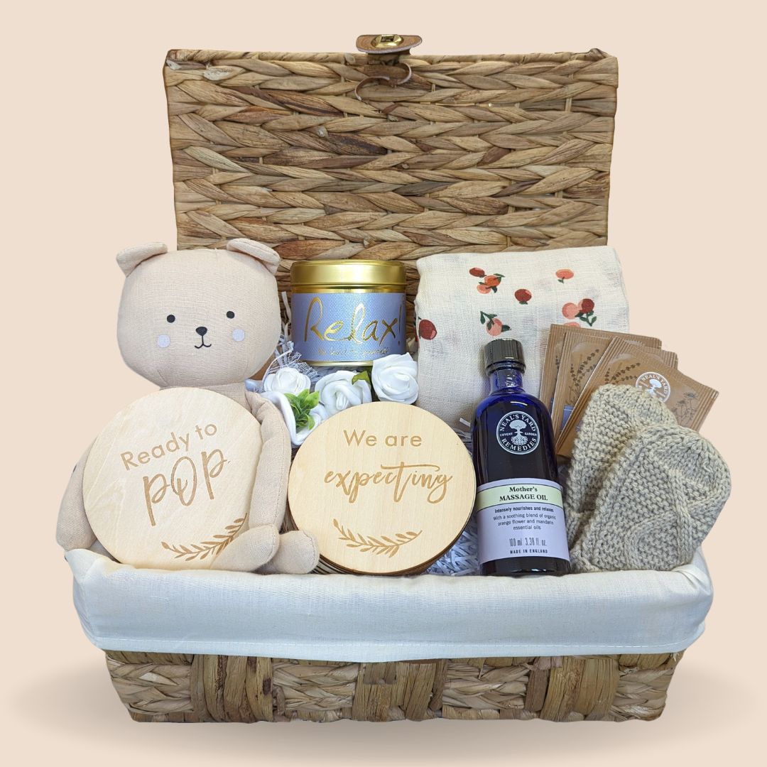 mum to be hamper basket with mothers massage oil, relaxation candle, organic tea, pregnancy discs, teddy bear, mittens and muslin swaddle.
