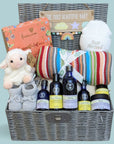 New baby hamper gift with skincare, blanket,  chocolates, lamb soft toy and baby hat.