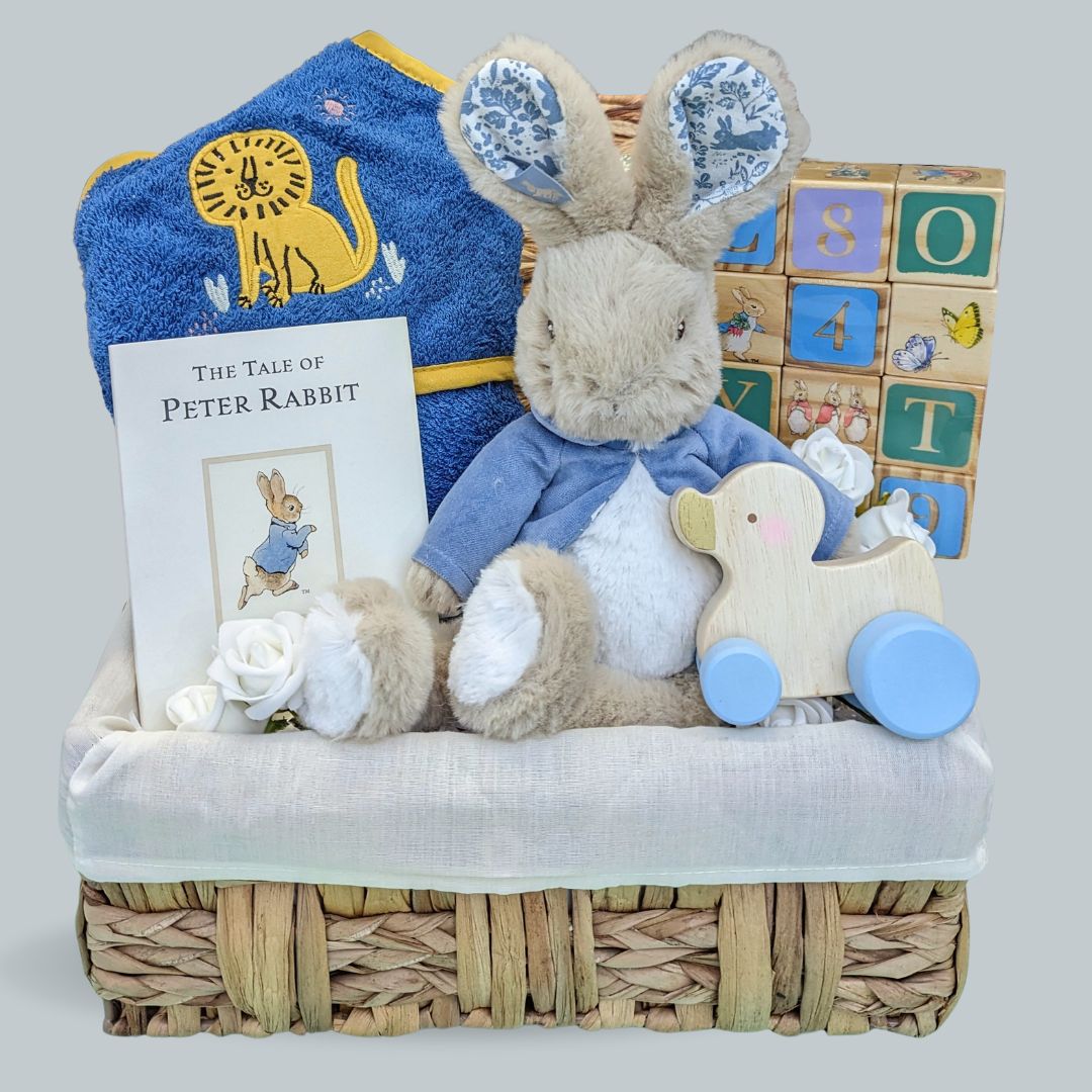 Adorable first birthday gift for a baby boy. Includes Peter Rabbit soft toy, building blocks, hooded organic towel, Peter Rabbit book and push along wooden toy.