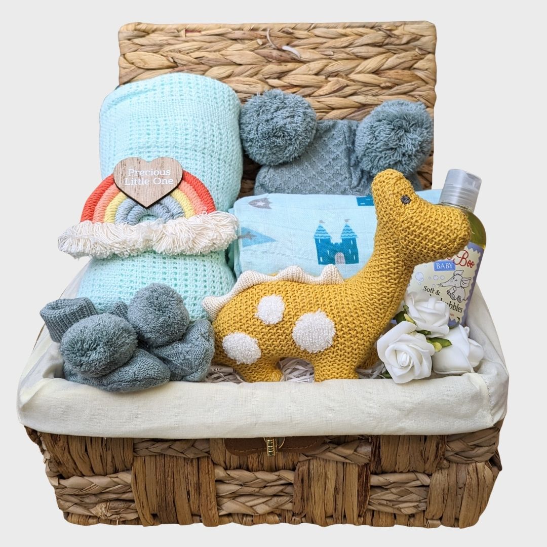 Beautiful new baby boy hamper. Comprises organic knit dinosaur soft toy, baby blanket, taggie ribbon sensory blanket, baby booties and muslin wrap.