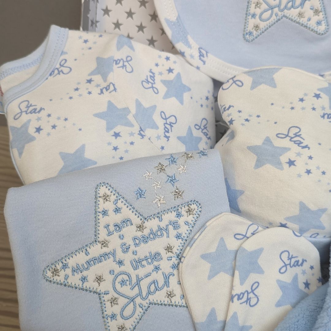 Blue baby clothes with star design in hamper.