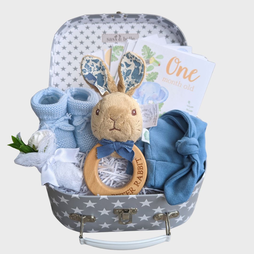baby boy hamper gift with peter rabbit rattle, baby booties, baby hat and baby milestone cards.