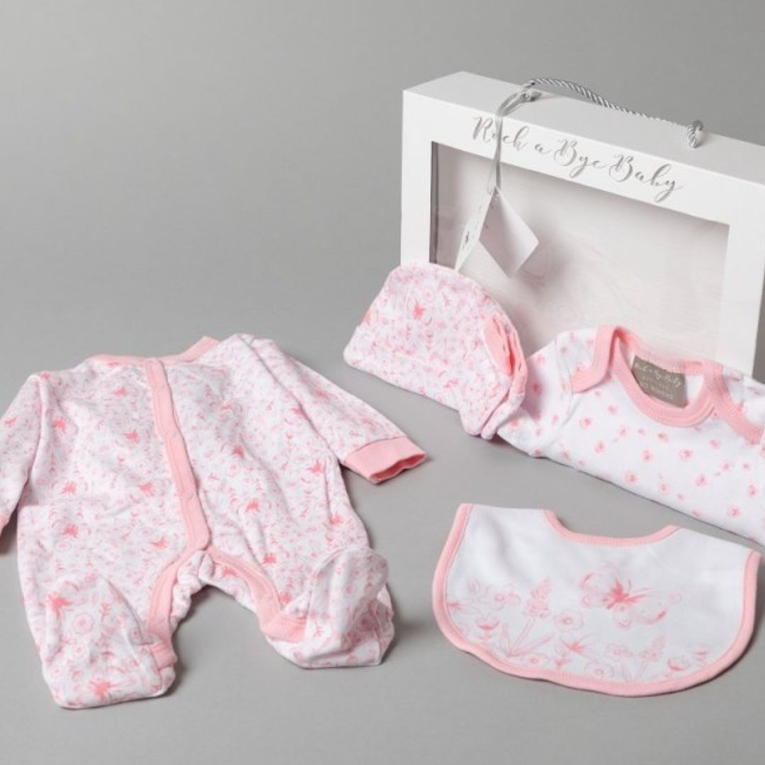 Pink and white baby clothing set with flowers and butterfly.