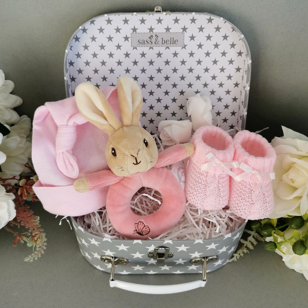 Baby girl hamper keepsake trunk with pink hat, baby booties and flopsy bunny rattle.