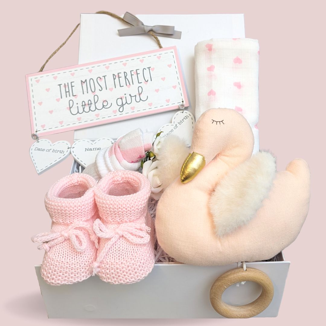 Baby girl hamper gift with organic swan soft toy, baby booties, hanging data plaque and muslin wrap.
