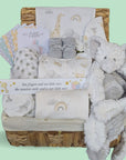 Baby gift hamper with gifts including white stars baby clothes and elephant baby comforter.