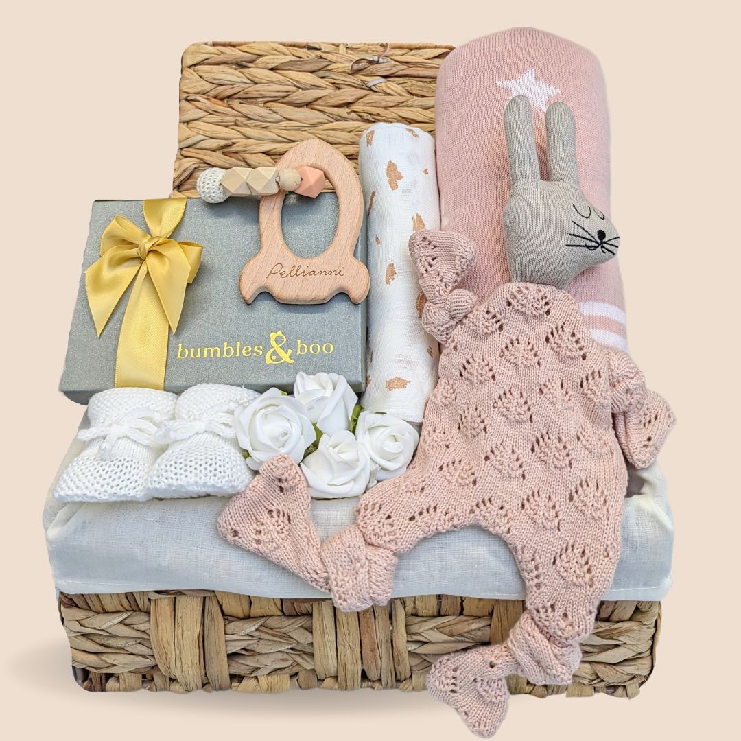 Stunning baby shower hamper which comprises organic muslin wrap, soft knit comforter, baby booties, blanket, rocket teether &amp; delicious chocolates for the mum to be.