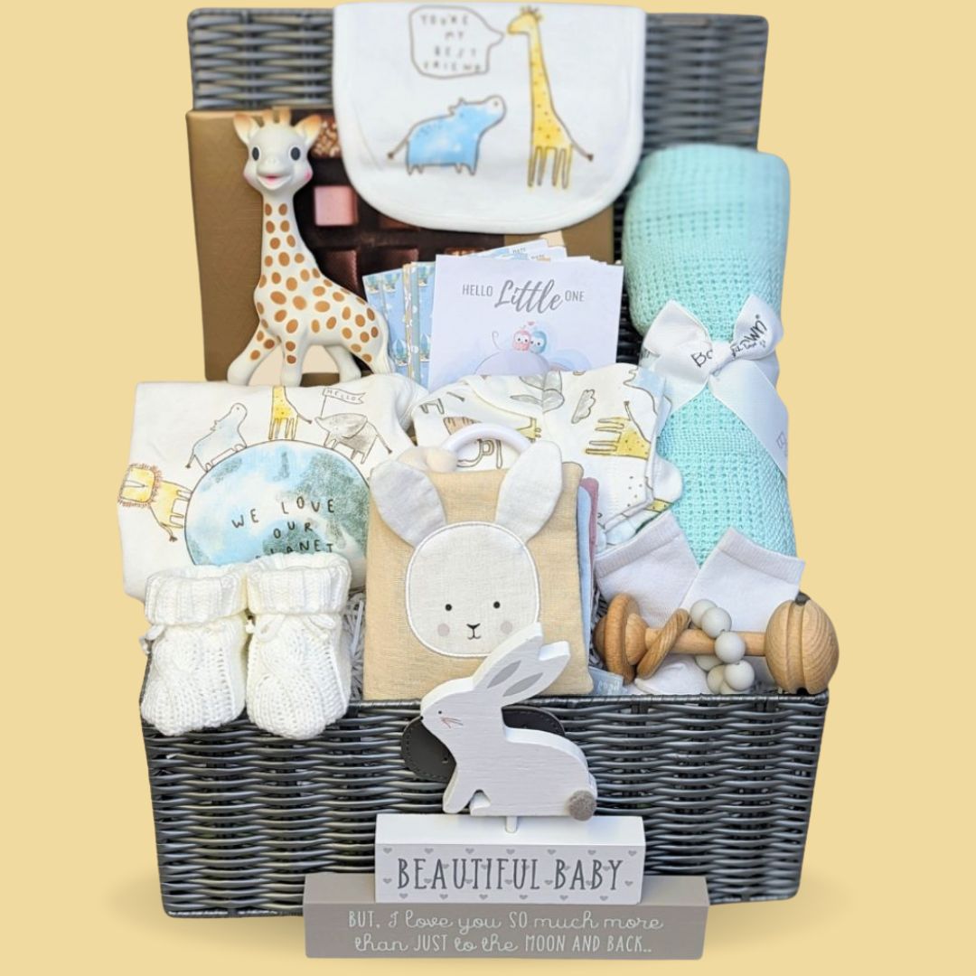 Baby shower hamper basket in brown packed with gifts in white, aqua and neutral colours.
