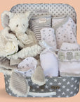 Baby shower hamper with gifts including baby clothes in white with grey stars and white elephant comforter in a grey hamper.