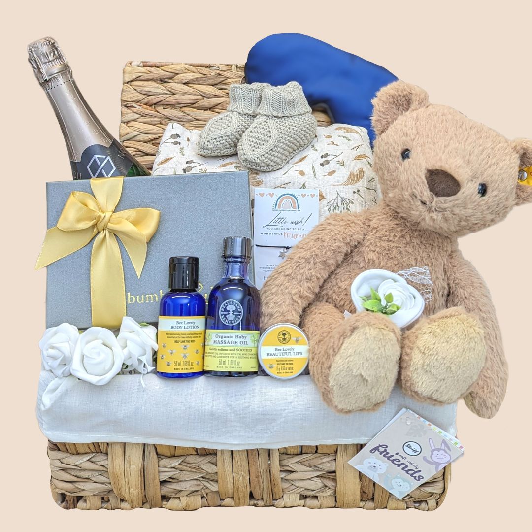 Baby shower hamper with gifts including teddy bear, chocolates and eye mask.