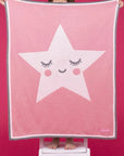 Large soft pink blanket with a white star in the middle with a smiling face.