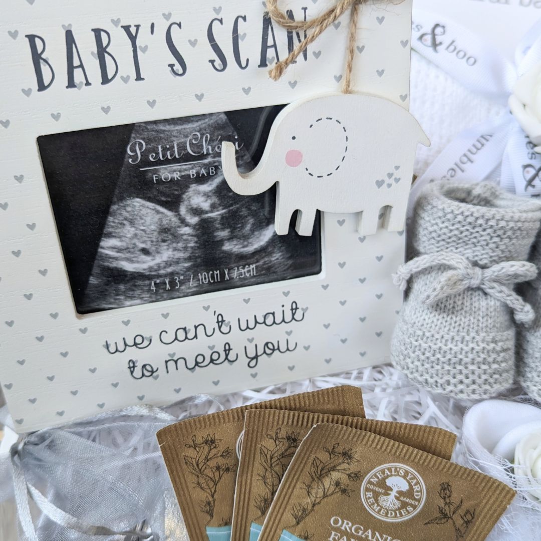 mum to be hamper box with dinner vouchers, baby scan frame, baby booties, blanket, bracelet and baby mittens.