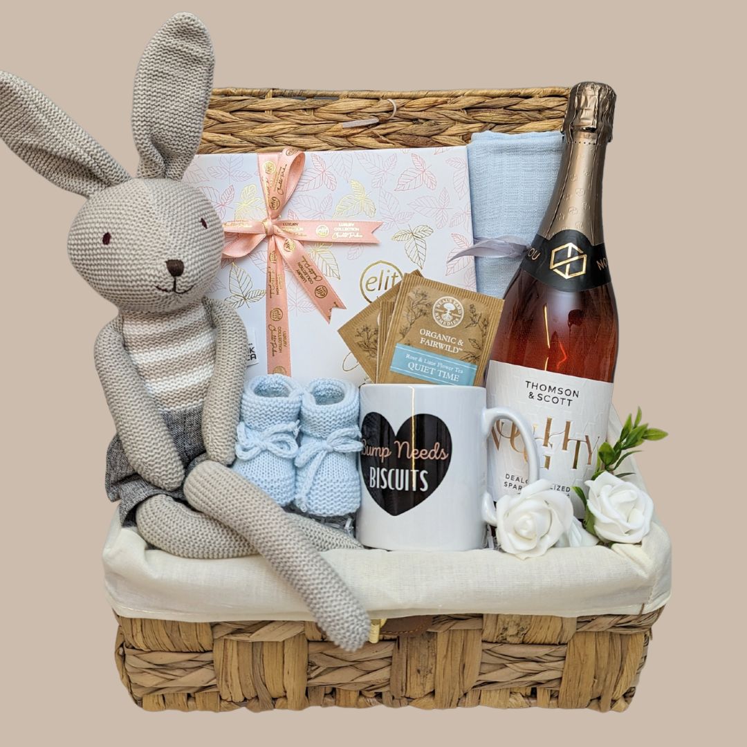 Mum to be hamper basket with chocolates for mum, alcohol free sparkling wine, mug, tea bags and knit bunny.