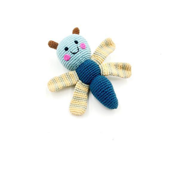 Handmade organic petrol blue dragonfly rattle toy with a smiling face, made from organic cotton with a polyester fill, on a white background.