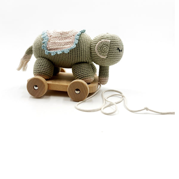 A handcrafted organic cotton elephant pull along toy with wooden wheels and a string handle, in shades of gray and blue.