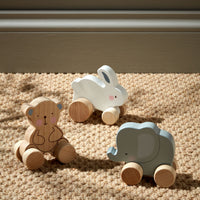Three animal push along wooden toys on wheels, including a bear, elephant, and rabbit, made from sustainable European Beech Wood