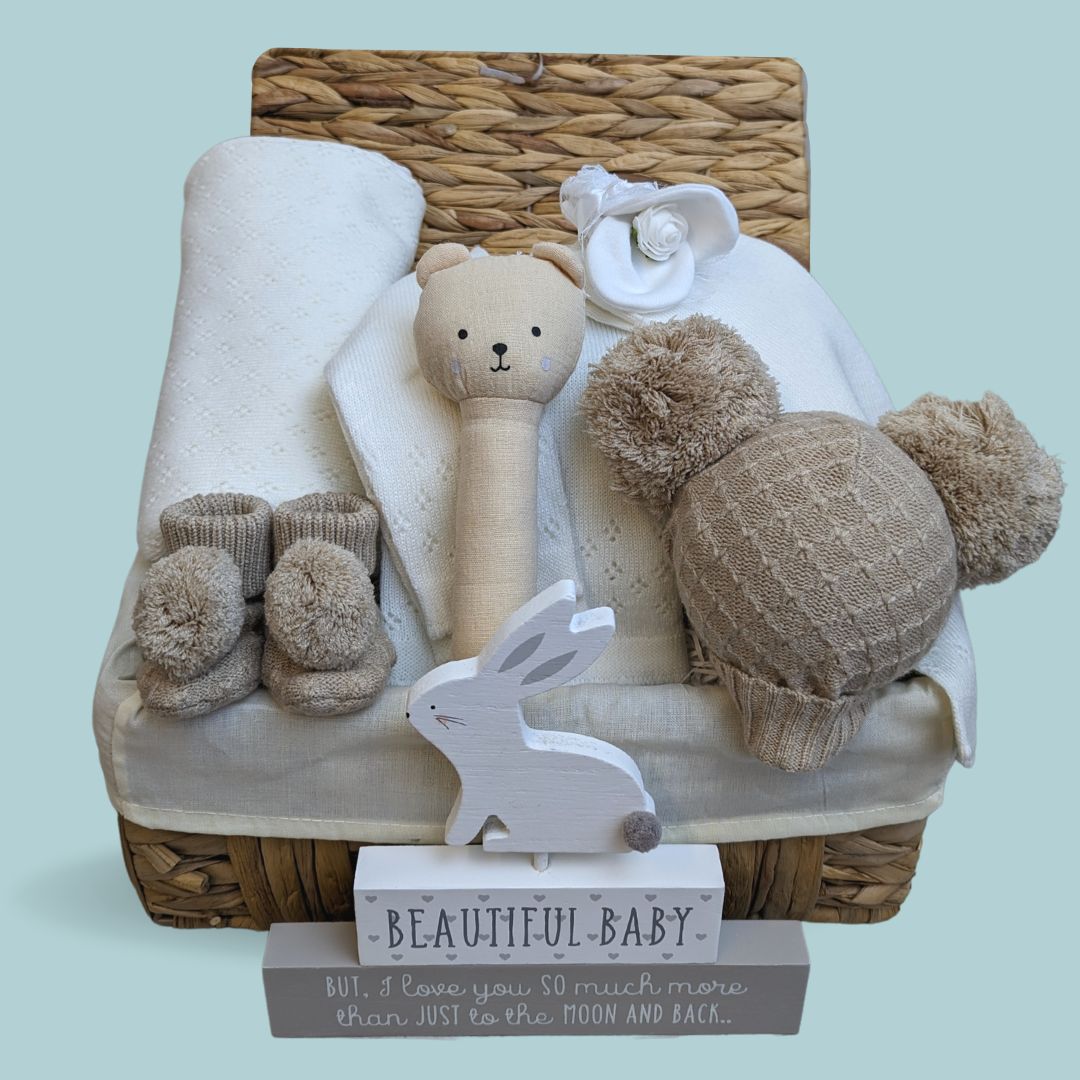 baby hamper basket with organic rattle, knit clothing set, booties and nursery plaque.