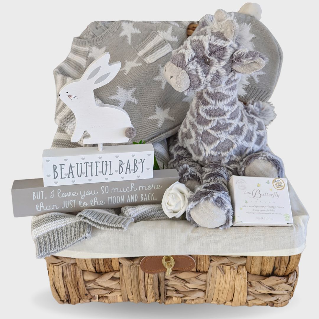 new baby hamper gift with giraffe, knit clothing, nursery hanging plaque and baby skincare.