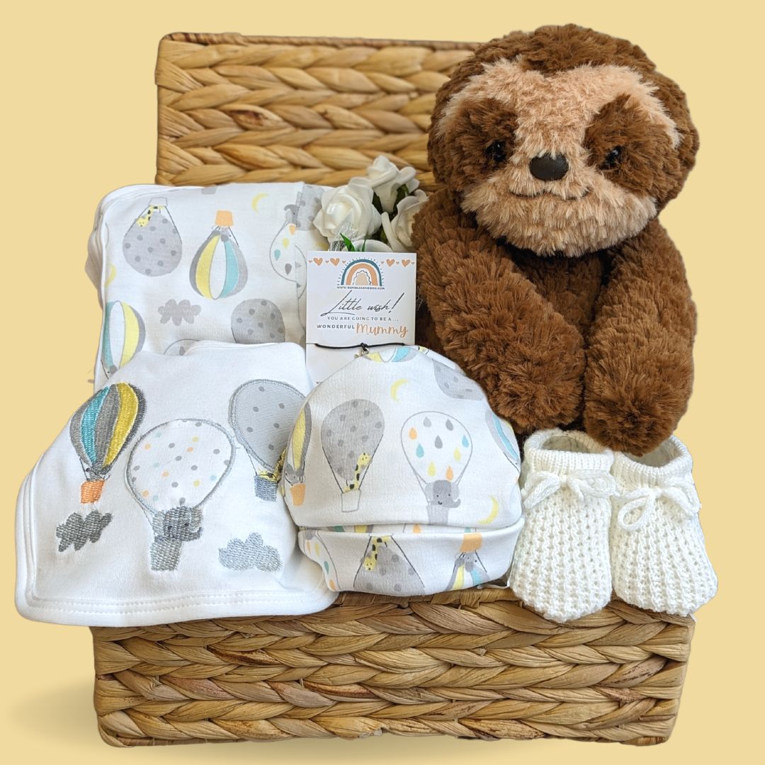 unisex baby hamper basket with sloth teddy, baby clothing set and little booties. 